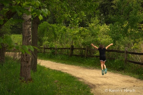 Youngster jumping in air along a trail